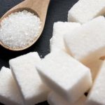sacharidy biely cukor na čiernom pozadí